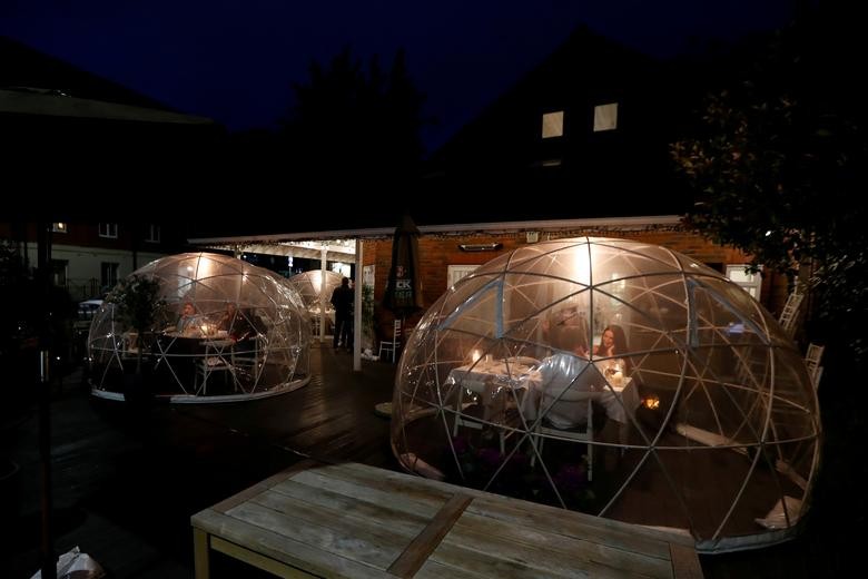 People sit in an outdoor area at St Villa bar and restaurant in St. Albans, Britain. REUTERS/Paul Childs  